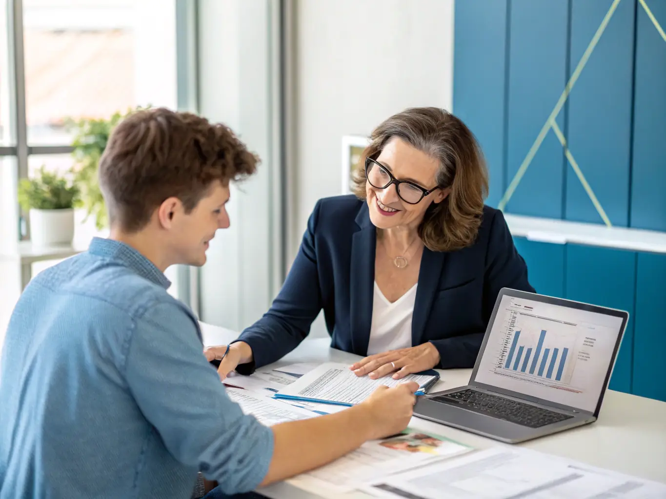 A focused accountant working one-on-one with a business coach in a modern office setting, reviewing financial documents and discussing strategies.